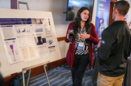 Showcase Your Research: This image shows two professionals having a conversation in front of a scientific poster
